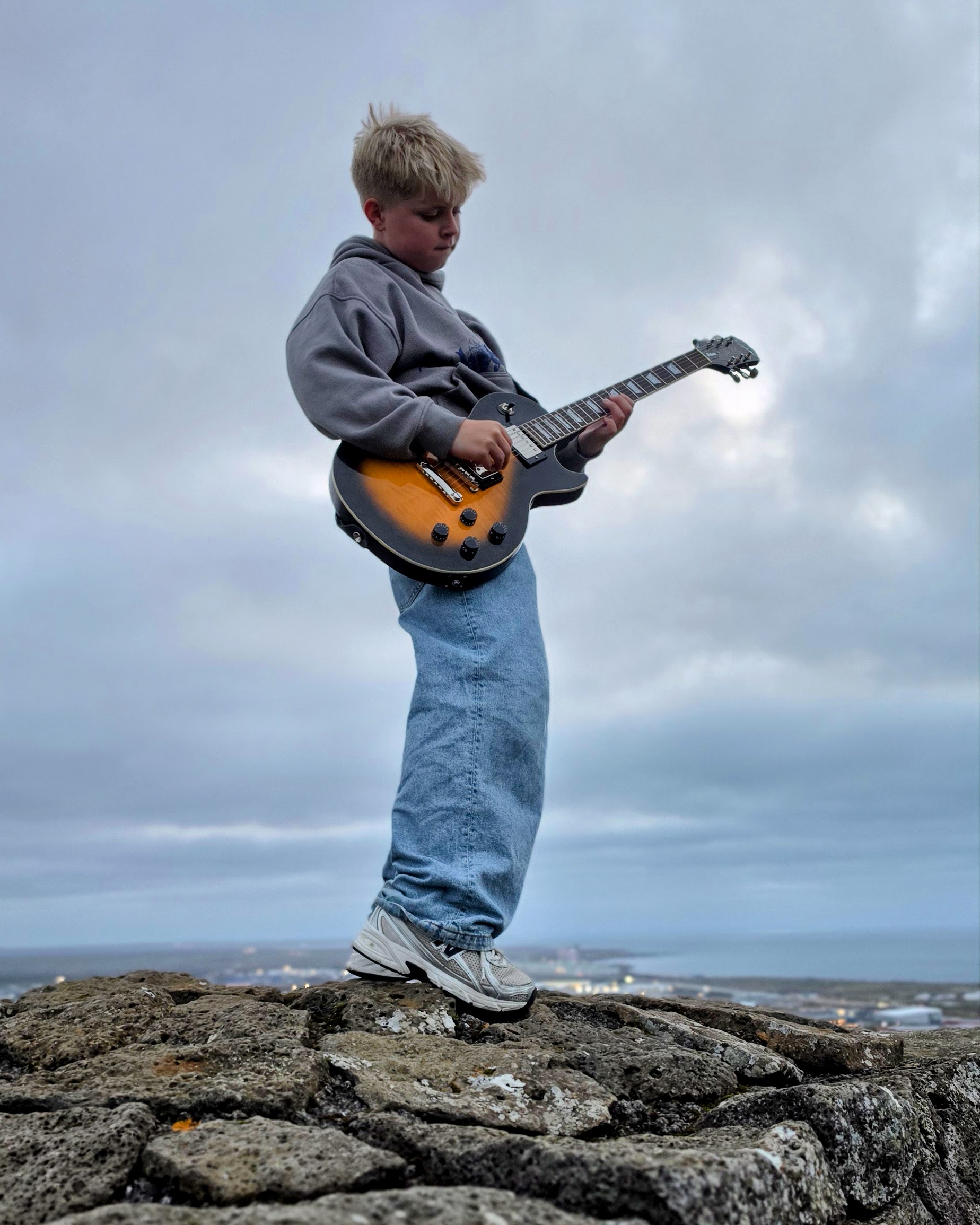 Matthias Thor playing a guitar on Asfjall in Hafnarfjordur, Iceland